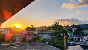 Un quartier résidentiel avec des maisons, des antennes paraboliques et un ciel dégagé au coucher du soleil.