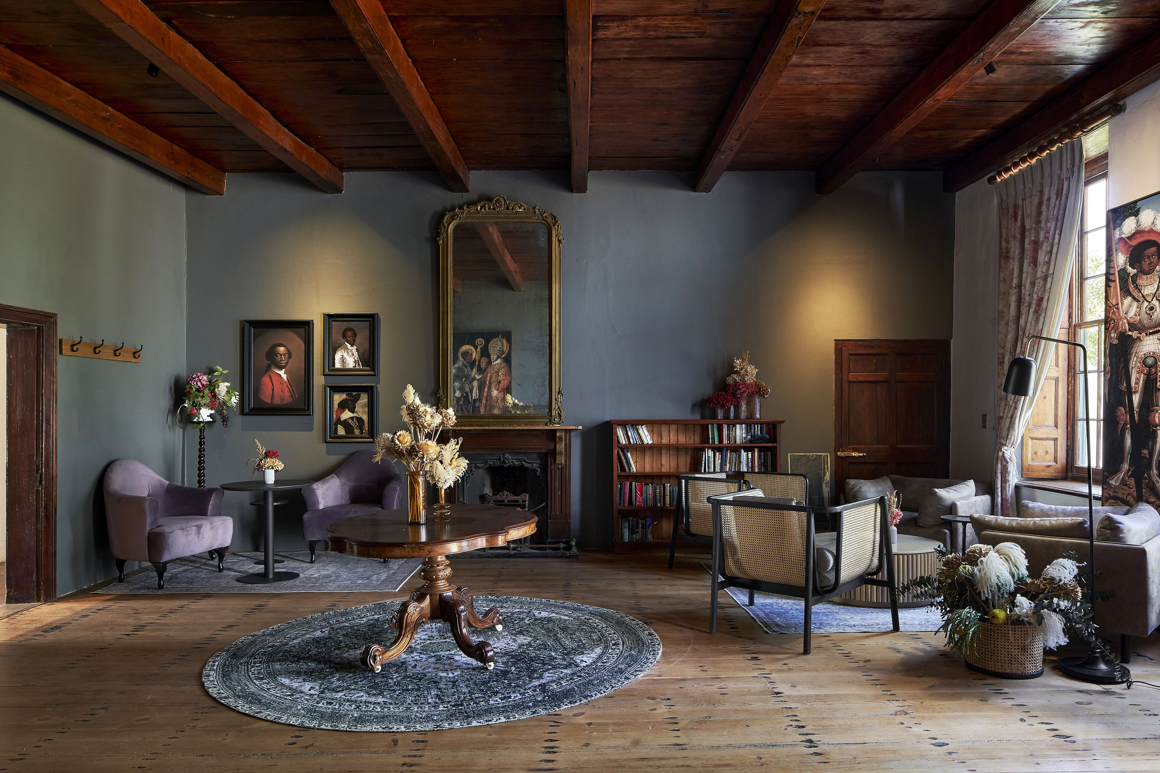 Un salon chaleureux avec un plafond en bois, une table basse ronde et une cheminée.