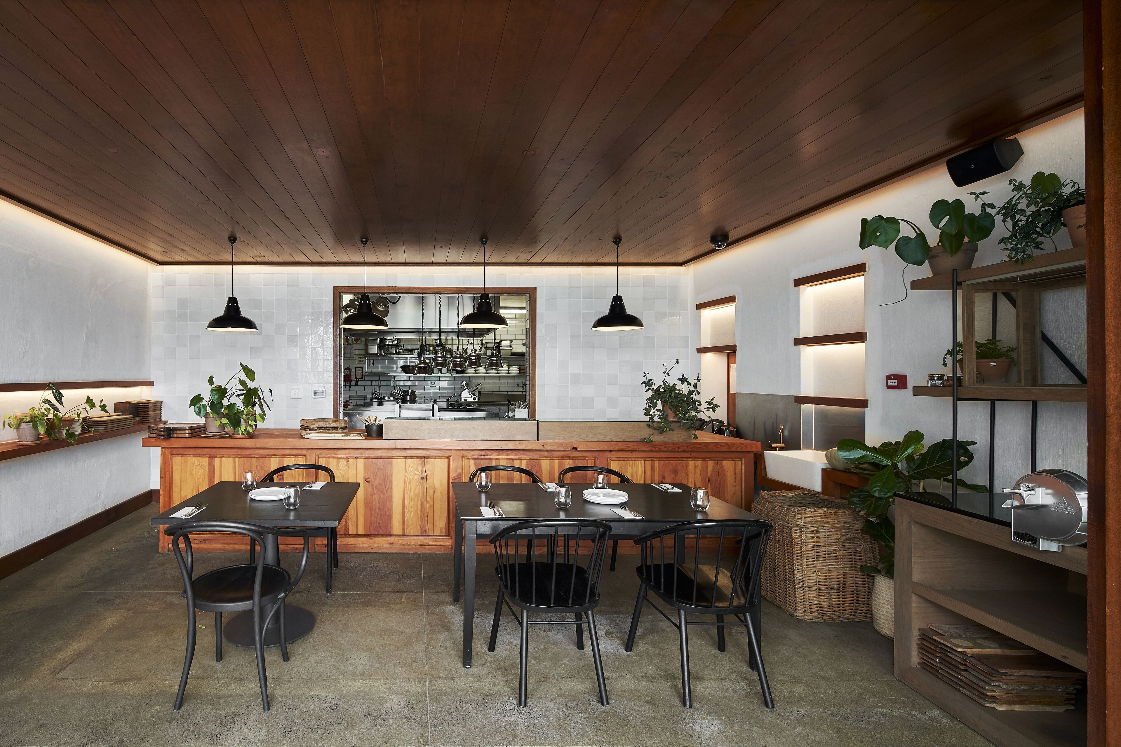 A modern kitchen with wooden cabinets, a central island, and pendant lighting.
