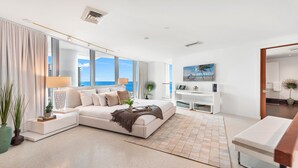 A modern living room with a large window, a sofa, a coffee table, and a TV.