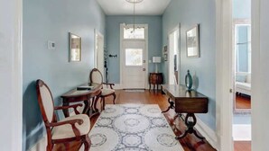 Un couloir avec un coin repas agrémenté de meubles en bois et d’un tapis à motifs.