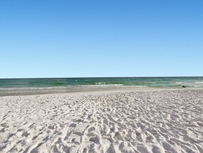 A sandy beach with gentle waves and a clear sky. - Amazing Beach House with Private Pool! (Destin)