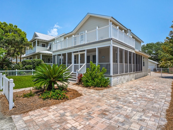 A two-story house with a covered porch and a screened balcony.