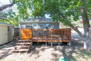 A wooden deck with steps leading to a house with a garage.