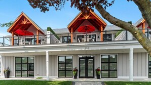 A two-story building with a balcony, large windows, and a number "252" on the facade. - The Lofts of Brick and Mortar-City Loft |Stylish |Walk-Out Balcony |2 Kings |Parking for 2 |Downtown (Lake Geneva)