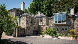 A stone house with a driveway, a wooden gate, and potted plants. - Granary Cottage -  a cottage that sleeps 2 guests  in 1 bedroom (Kingsbridge)
