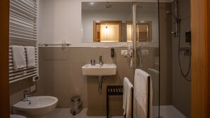 A modern bathroom with a glass shower enclosure, a white sink, a bidet, and a towel rack. - B&B GIALLO - Felce Wellness Room (Pieve di Cadore)