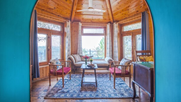 A cozy room with wooden walls and ceiling, a sofa, two chairs, a small table, and a pool table. - Seclude Nahan Bantony Cottage (Paonta Sahib)
