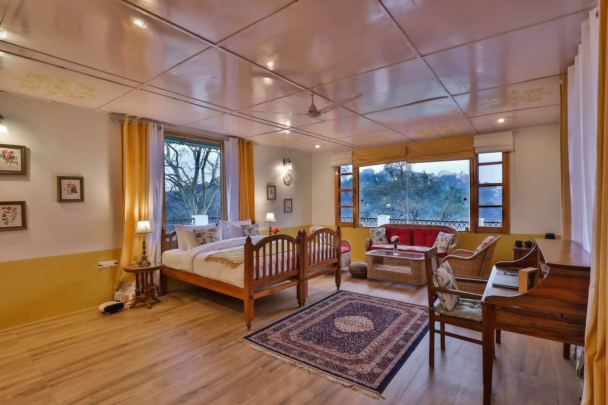 A spacious room with a wooden bed, a dining table, and a sofa.