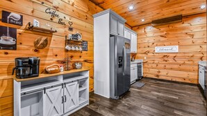 Eine Küche mit Holzwänden, einer Kaffeebar und einem Kühlschrank.