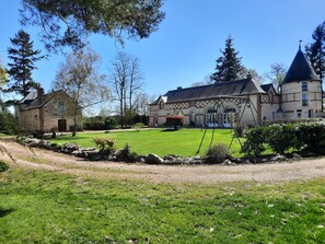 Un vaste domaine comprenant une maison principale, un bâtiment plus petit et une tour.