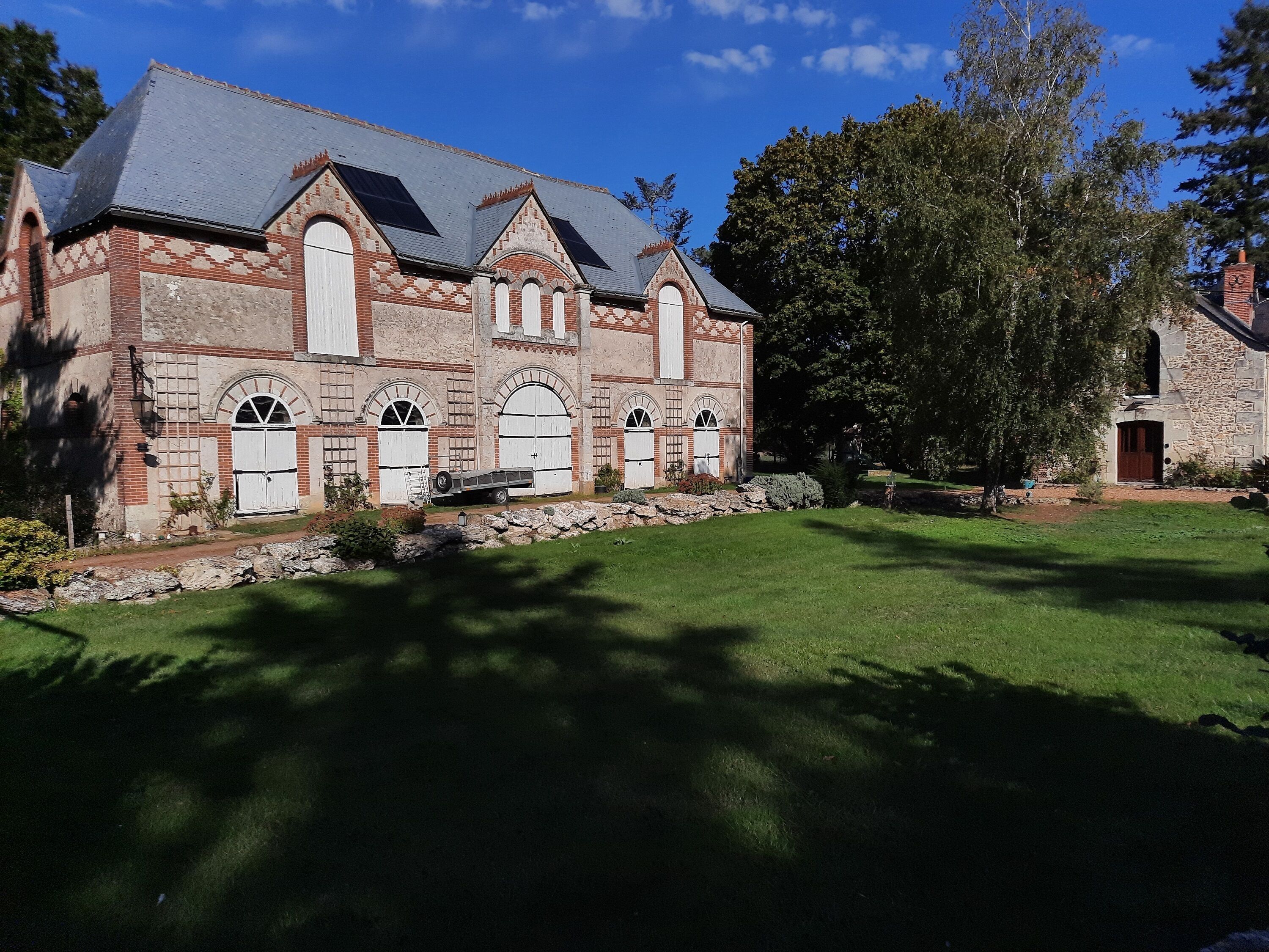 A historic building with a stone facade, arched windows, and a stone chimney.