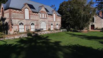 A historic building with a stone facade, arched windows, and a stone chimney.