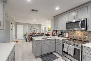 Enjoy cooking in this well-lit kitchen with an oven, microwave, and large island with a sink.