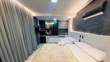 A modern bedroom with a large bed, a built-in wardrobe, and a vanity with a mirror.