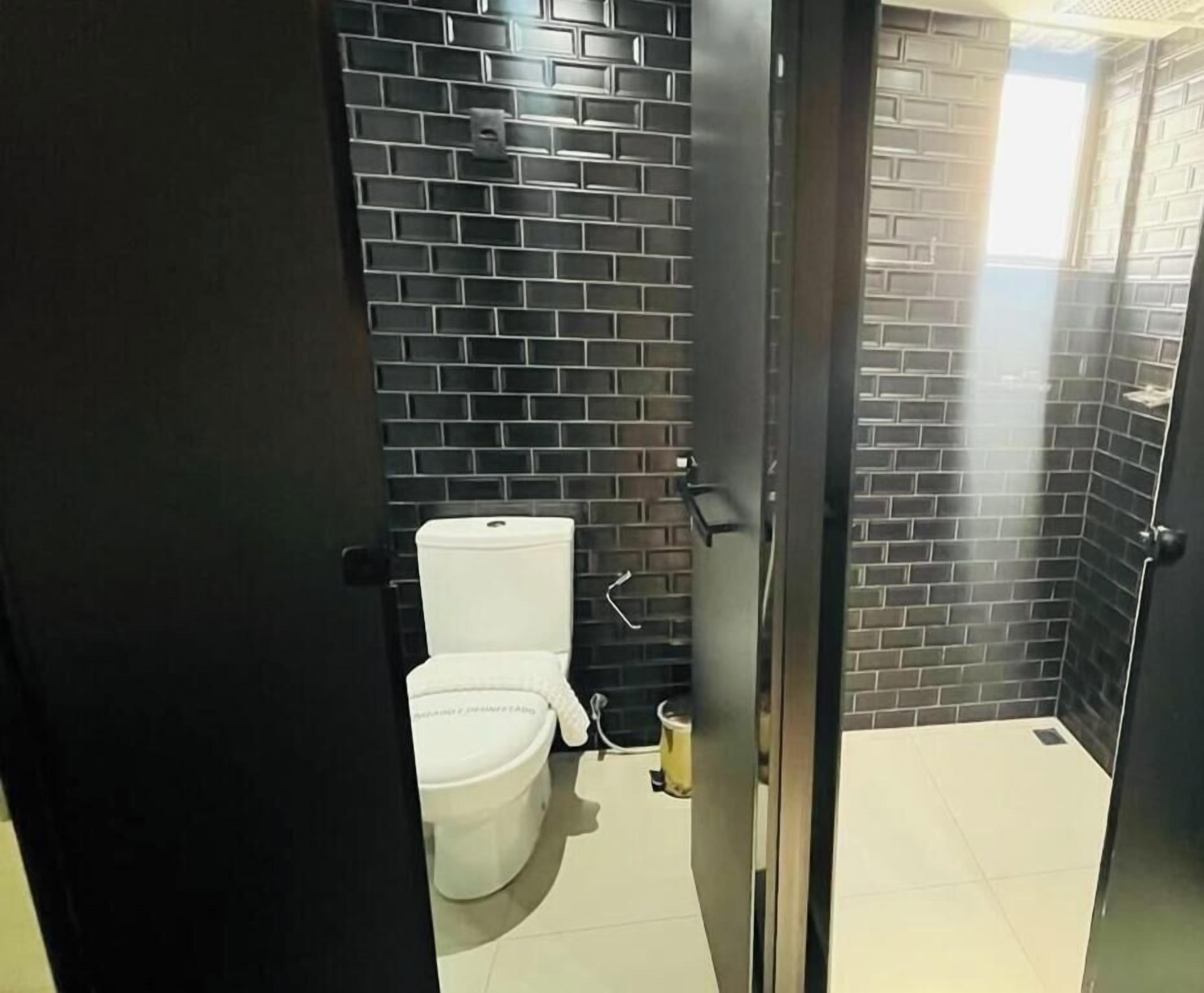 Un baño con inodoro, lavamanos y zona de ducha.