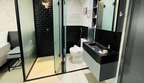 A modern bathroom with a glass shower enclosure, a white toilet, and a black vanity with a mirror. - LM HOSPEDAGENS - GET ONE (João Pessoa)