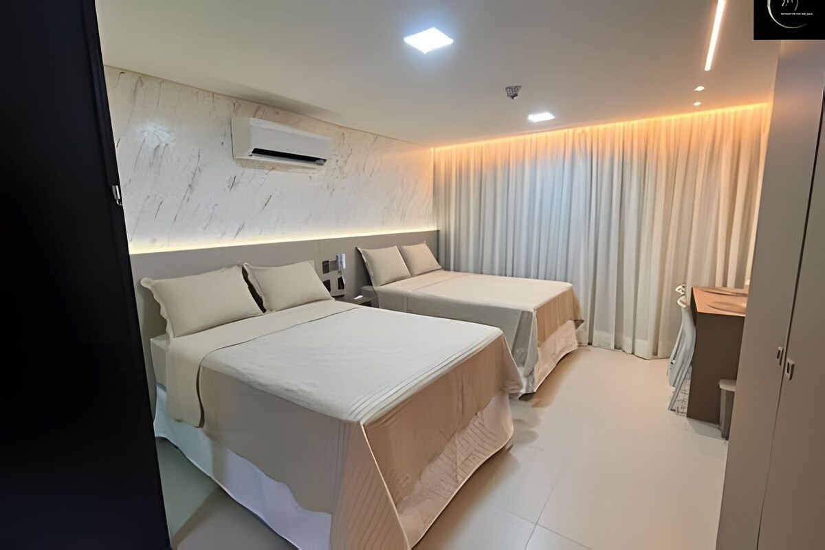 Een moderne hotelkamer met twee bedden, een wand met marmeren details, een airconditioningsysteem en een gordijn.