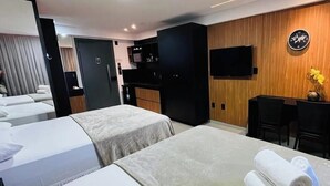 A hotel room with two beds, a desk, a flat-screen TV, and a wooden wall. - LM HOSPEDAGENS - GET ONE (João Pessoa)