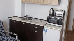 A compact kitchenette with a sink, microwave, toaster, and a refrigerator. - Beautiful 1-bed Studio in Sunny Beach Bulgaria (Nessebar)