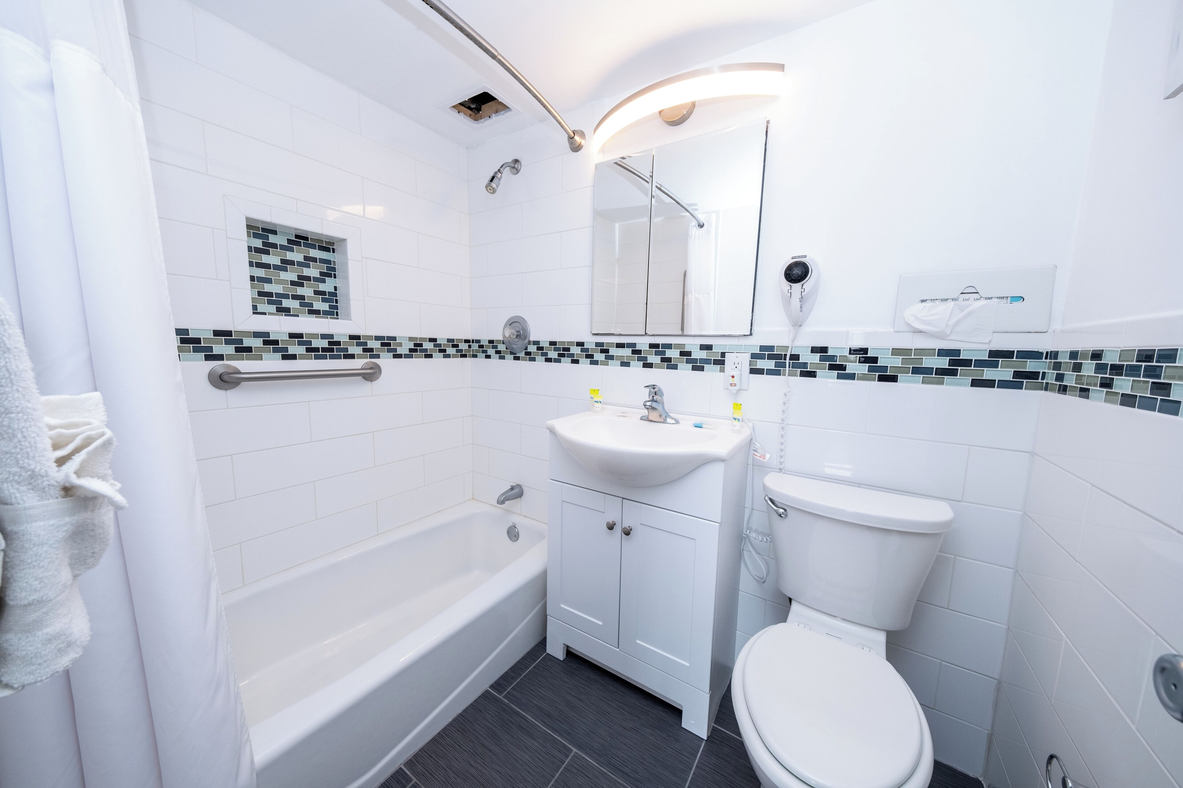 Ein modernes Badezimmer mit einer Badewanne, Toilette und Waschbecken.