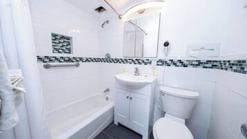 Ein modernes Badezimmer mit einer Badewanne, Toilette und Waschbecken.