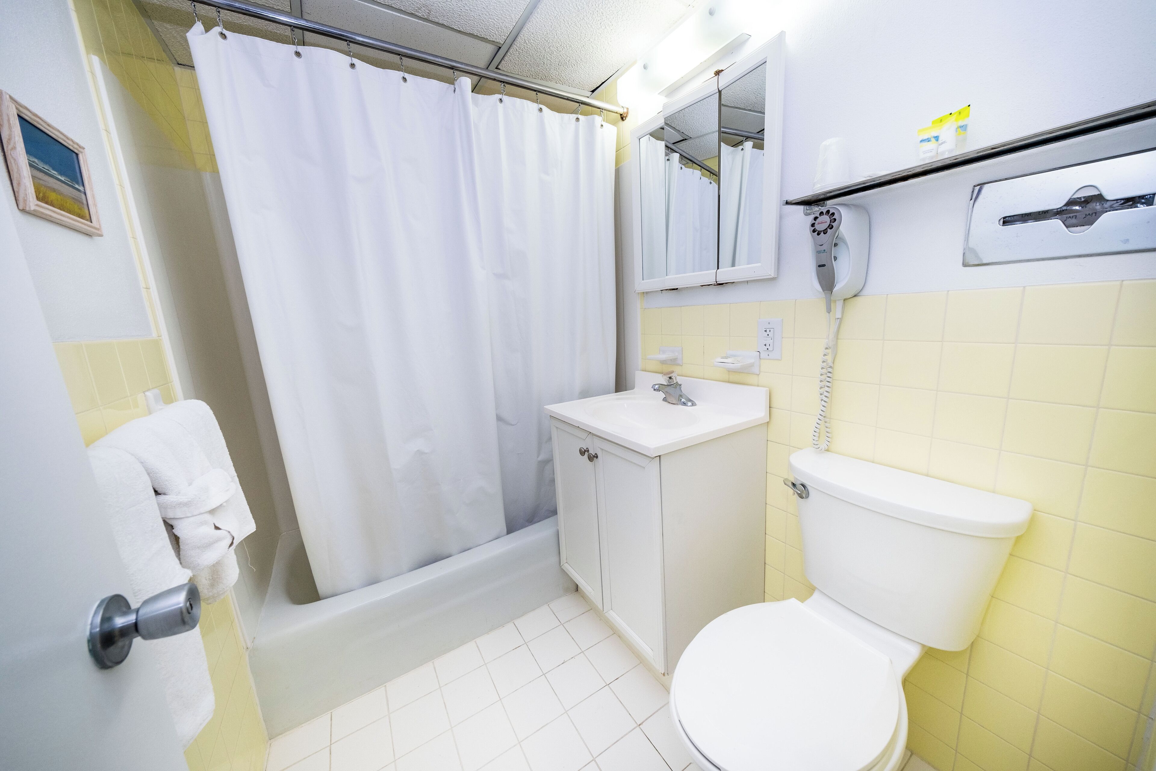 Un baño con bañera, inodoro, lavabo y cortina de ducha.