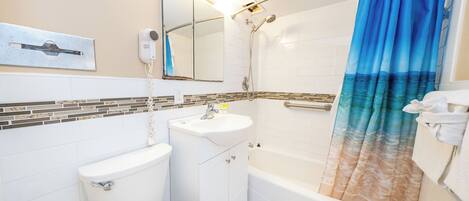 A bathroom with a toilet, sink, and bathtub.