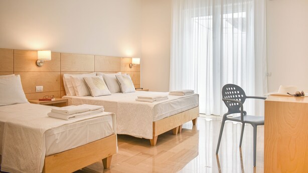 A hotel room with two beds, a desk, and a chair. - Ammarèa B&B (Ugento)
