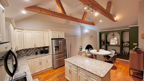 A modern kitchen with white cabinets, a granite countertop, and a stainless steel refrigerator. - Tranquil Cape getaway 4BD 2BA with AC, Family and Pet Friendly!  (Mashpee)