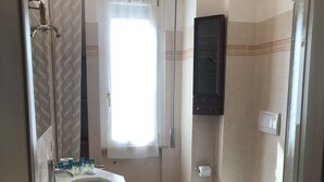A bathroom with a sink, mirror, toilet, and shower. - Comfortable Apartment center Sarzana (Sarzana)