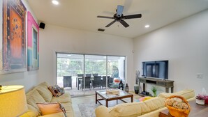 A spacious living room with a sofa, coffee table, and TV.