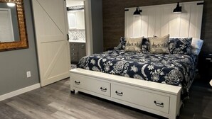 Un dormitorio con cama, una puerta corrediza, un tocador y un espejo.