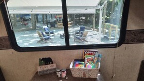 A small kitchenette area with a window overlooking a covered outdoor seating area.