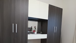 A room with a dark wooden wardrobe, a white sink, and a mirror above it. - Authentic Lebanon - Charming, welcoming property in the heart of Magdouché (Maghdoucheh)