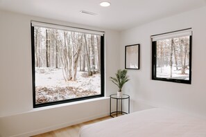 Enjoy a peaceful retreat with a single bed and serene forest views.
