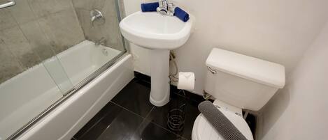 A bathroom with a bathtub, a sink, and a toilet.