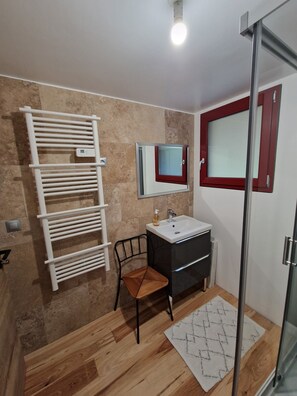 Chuveiro, secador de cabelo, toalhas de banho, papel higiênico