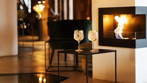 A modern interior with a fireplace, two glasses of water on a table, and a black chair in the background. - La Fábrica del Canal - Hotel Boutique (Adults Only) (Abarca de Campos)
