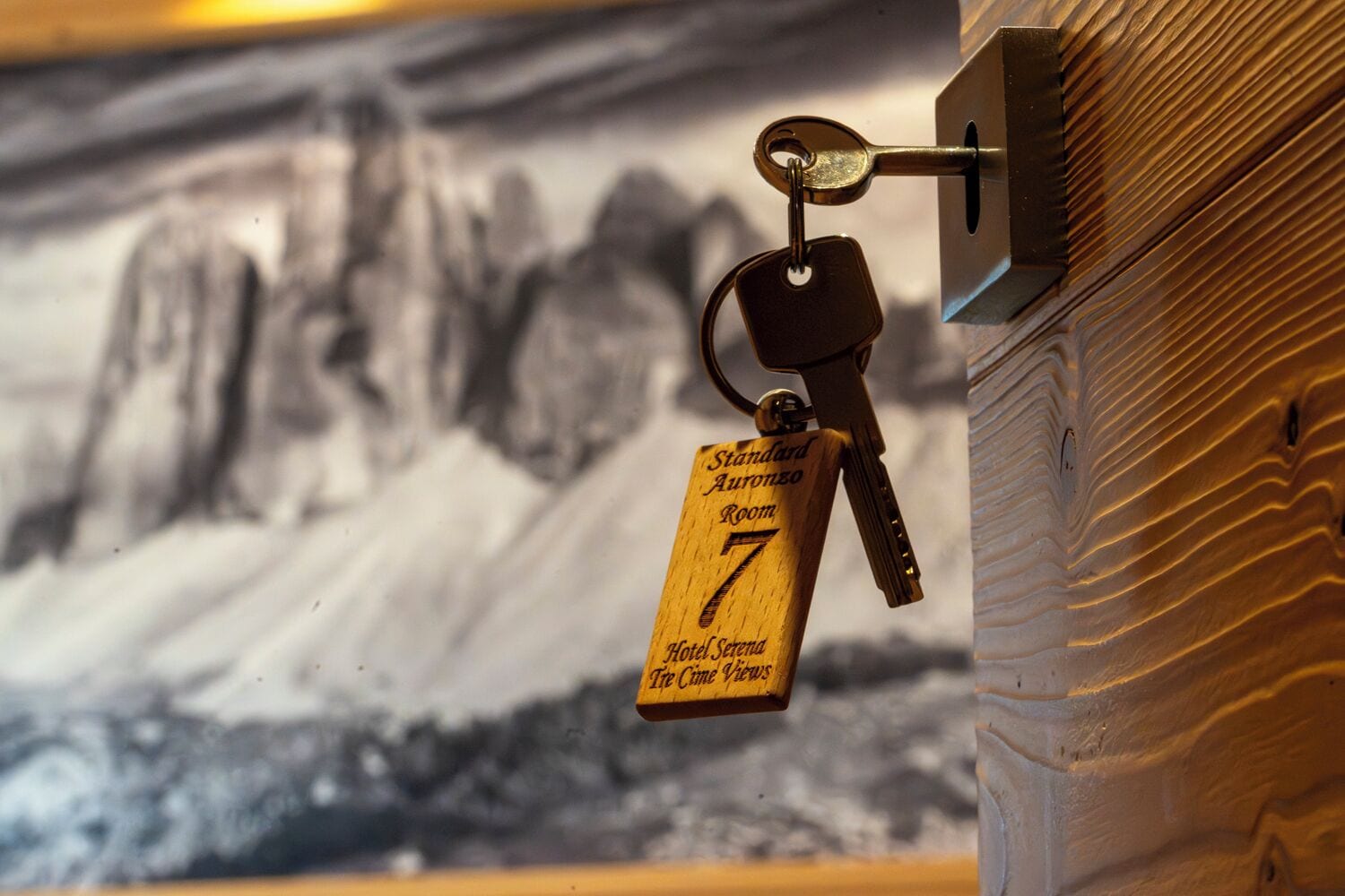 Una llave con una etiqueta de madera que dice 'Standard Aurora 7 Hotel Serena Tree Line Views'.