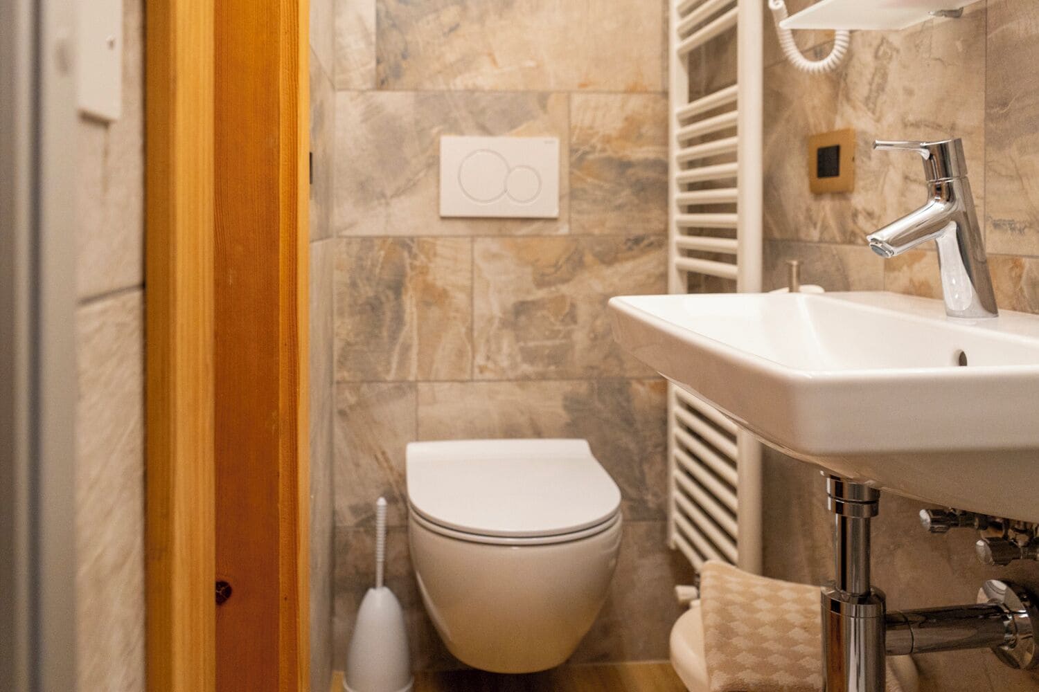 Un bagno con un lavandino bianco, un water e un porta asciugamani.