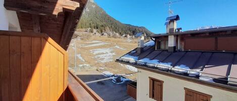 Ein Balkon mit Blick auf eine verschneite Landschaft und einen Berg.