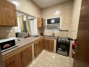 Comfort Apartment | Private kitchen | Full-size fridge, oven, cookware/dishes/utensils, dining tables - Al Homur Building (Salalah)