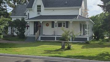 A two-story house with a gabled roof, a front porch, and a small front yard.