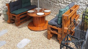 Ein Sitzbereich im Freien mit Holzmöbeln und einem großen Sonnenschirm.