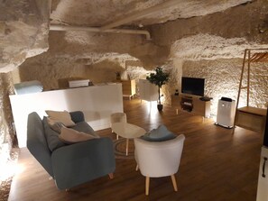 Ein modernes Wohnzimmer mit Steinwand, einer Couch, einem Couchtisch und einem Fernseher.