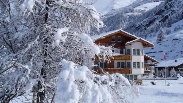 A two-story chalet with a wooden facade, surrounded by snow-covered trees and mountains. - Amaryllis by Interhome (Saas-Grund)