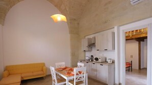 A compact living space with a dining area, kitchenette, and a yellow sofa. - Spicchi di Salento - Arancio by Interhome (Vernole)