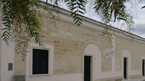 A building with a stone facade, arched doorways, and a sign that reads "Hotel de la Palma". - Spicchi di Salento - Arancio by Interhome (Vernole)