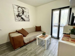 Una sala de estar moderna con un sofá, una mesa de centro y un ventanal grande.